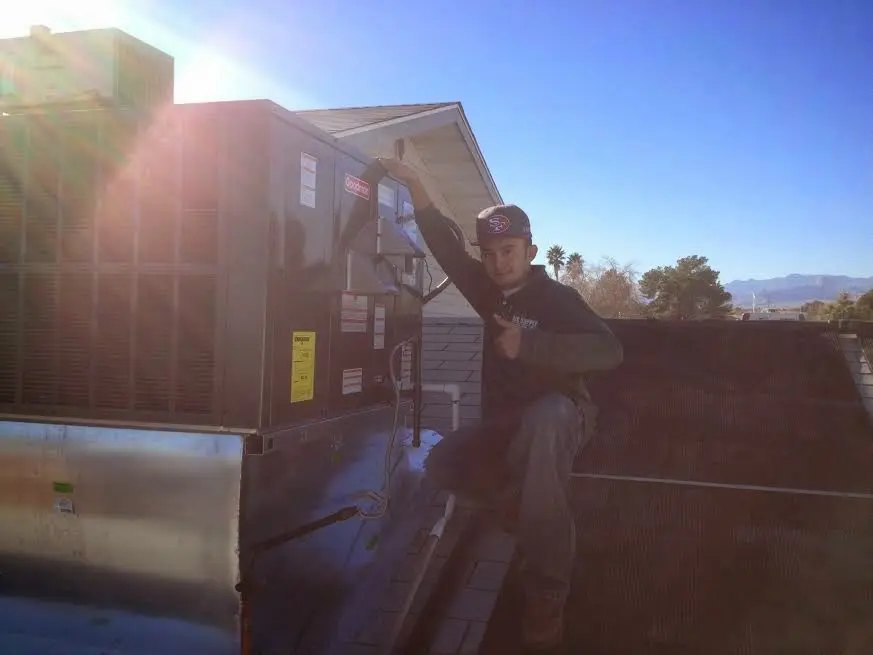 HVAC technician performing AC Tune-Up on a rooftop unit in Gardiner